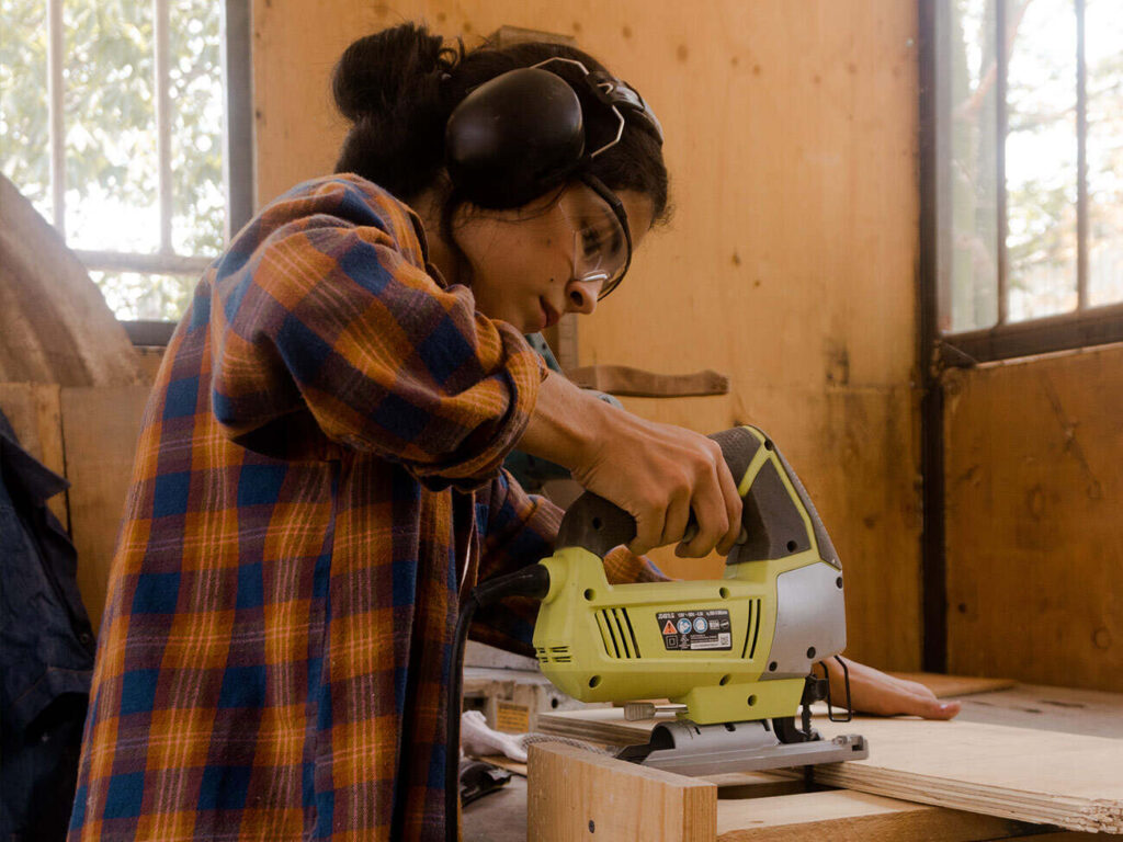 Una ragazza usa la levigatrice durante il bricolage